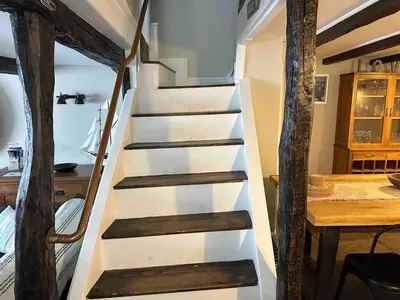 a staircase in a room with a wooden table at Character 3 Bed Cottage, Close to Waters edge, Parking in Looe