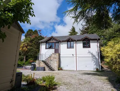 a white house with a garage at Near Eden Project apartment in Trethurgy