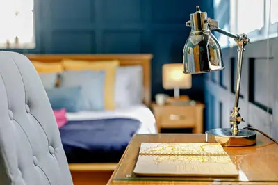 a desk with a lamp on a table with a bed at 1 Bed in Fowey oc-m27634 in Fowey