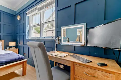 a bedroom with blue walls and a desk with a computer at 1 Bed in Fowey oc-m27634 in Fowey