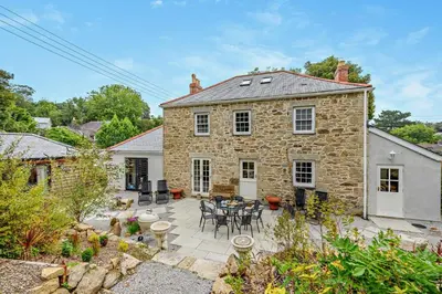 an exterior view of a stone house with a patio at 4 Bed in Penryn oc-c27969 in Penryn