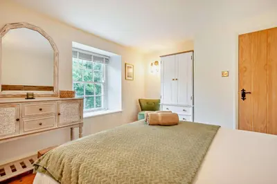 a bedroom with a bed and a mirror and a chair at 4 Bed in Penryn oc-c27969 in Penryn