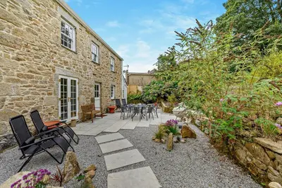 a patio with chairs and tables in front of a building at 4 Bed in Penryn oc-c27969 in Penryn