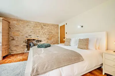 a bedroom with a large bed and a stone wall at 3 Bed in Penryn oc-chy969 in Penryn