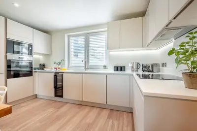 a kitchen with white cabinets and a large window at 2 Bed in Padstow oc-h32002 in Padstow