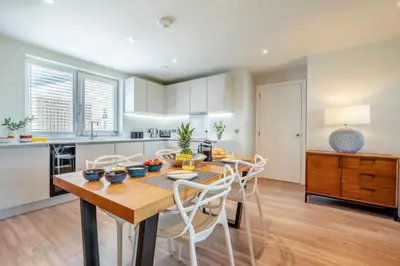 a kitchen with a wooden table and white chairs at 2 Bed in Padstow oc-h32002 in Padstow