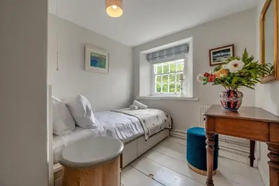 a small bedroom with a bed and a table at 5 Bed in Tredethy oc-t31962 in Saint Mabyn