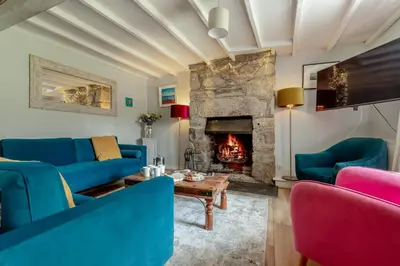 a living room with blue couches and a fireplace at 5 Bed in Tredethy oc-t31962 in Saint Mabyn