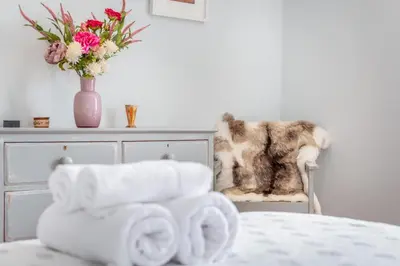 a pile of towels sitting in a chair next to a bed at 5 Bed in Tredethy oc-t31962 in Saint Mabyn
