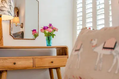 a vase of flowers on a table next to a mirror at 2 Bed in Padstow oc-f32031 in Padstow