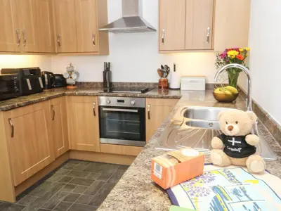 a teddy bear sitting on a counter in a kitchen at The Stable Barn in Hayle
