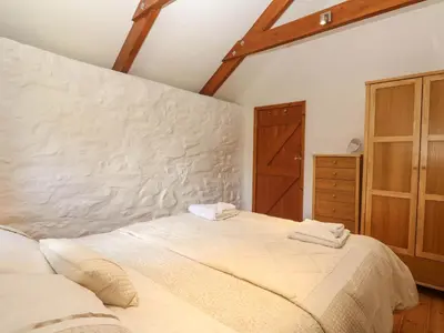 a bedroom with a large bed with two towels at Bay View Barn in Hayle