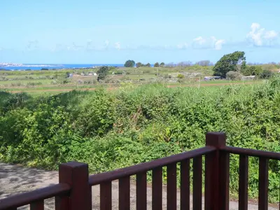 a wooden fence with a view of a field at Bay View Barn in Hayle