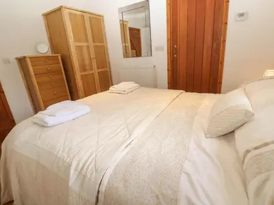a bedroom with a large bed with two towels on it at Bay View Barn in Hayle