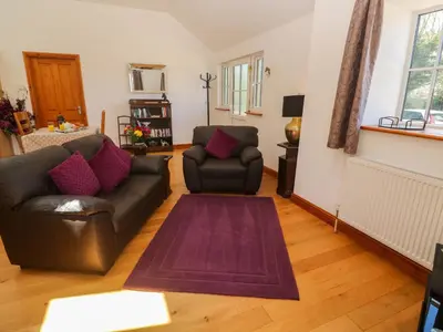 a living room with a couch and two chairs at The Coach House in Hayle