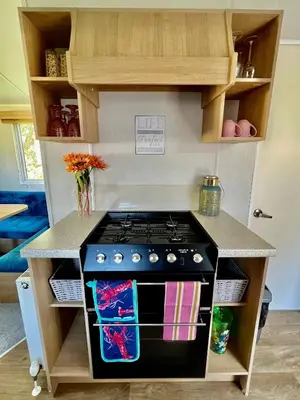 a kitchen with a stove and a counter top at 3 Bedroom Caravan with Decking at Newquay Bay Resort in Porth