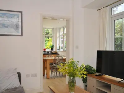 a living room with a television and a table at Falmouth Bay 1 in Falmouth