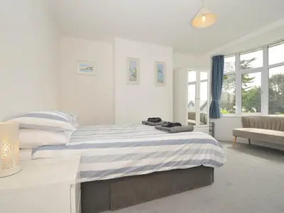 a white bedroom with a bed and a couch at Falmouth Bay 1 in Falmouth