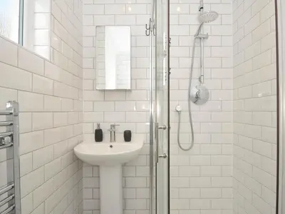 a white bathroom with a sink and a shower at Falmouth Bay 1 in Falmouth
