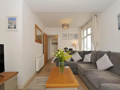 a living room with a couch and a table with flowers at Falmouth Bay 1 in Falmouth