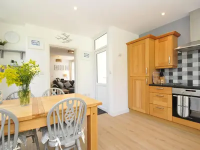 a kitchen and dining room with a wooden table and chairs at Falmouth Bay 1 in Falmouth