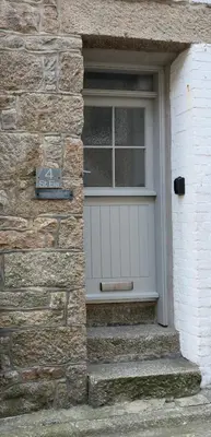 a front door of a stone house with a window at 4 St Eia - Happy Place in St Ives