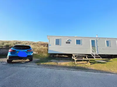 a car parked next to a mobile home at Dune Breeze-Haven Perran Sands Holiday Park in Perranporth
