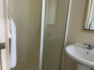 a bathroom with a shower and a sink at Newquay - Pet Friendly 6 Berth Caravan in Newquay