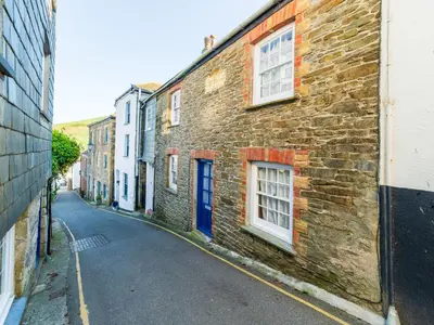 an old brick building with a blue door on a street at Holiday Home Seaforth by Interhome in Gorran Haven