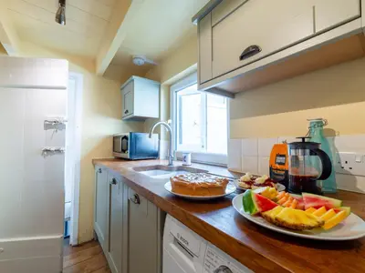 a kitchen with two plates of fruit on a counter at Holiday Home Seaforth by Interhome in Gorran Haven
