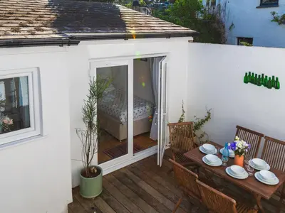 a patio with a table and chairs and a bed at Holiday Home Seaforth by Interhome in Gorran Haven