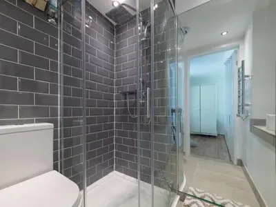 a bathroom with a glass shower with a toilet at Holiday Home Seaforth by Interhome in Gorran Haven