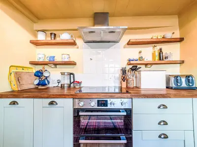 a kitchen with white cabinets and a stove at Holiday Home Seaforth by Interhome in Gorran Haven