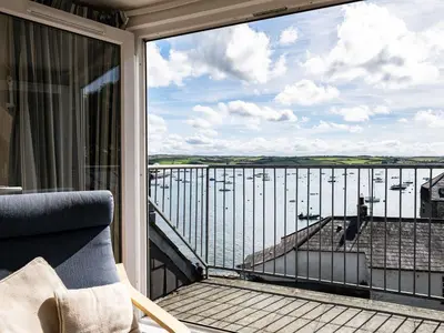 a balcony with a chair and a view of the water at 6 Slipway in Padstow
