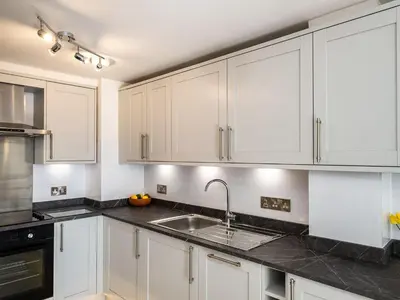 a kitchen with white cabinets and a sink at 6 Slipway in Padstow