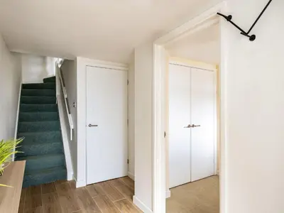 a white hallway with stairs and a stair case at 6 Slipway in Padstow
