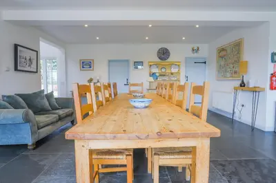 a wooden table and chairs in a living room at Trewidden in Polzeath
