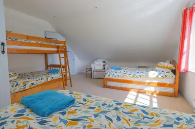 a bedroom with two bunk beds and a ladder at Trewidden in Polzeath