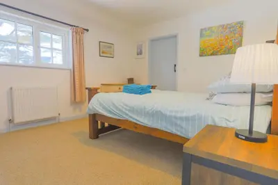 a bedroom with a bed and a lamp on a table at Trewidden in Polzeath