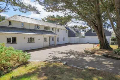 a large white house with a large driveway at Trewidden in Polzeath