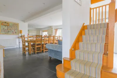 a kitchen and dining room with a table and chairs at Trewidden in Polzeath