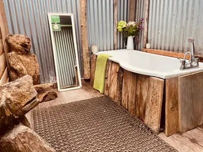 a bathroom with a bath tub and a sink at Wrens Nest in Saint Mabyn
