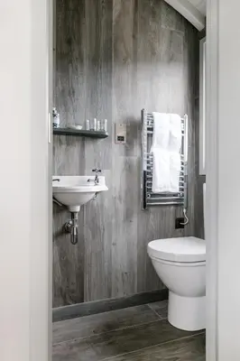 a bathroom with a white toilet and a sink at Shepherds Huts at The Cornish Arms in St Merryn
