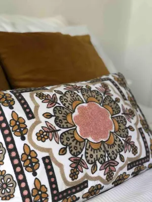 a pillow with a flower pattern on a bed at Stylish Room Close to Beaches in Falmouth