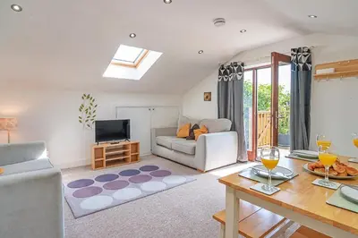 a living room with a couch and a table at Finest Retreats - Stable Barn Apartment at Bodmin Moor in Saint Breward