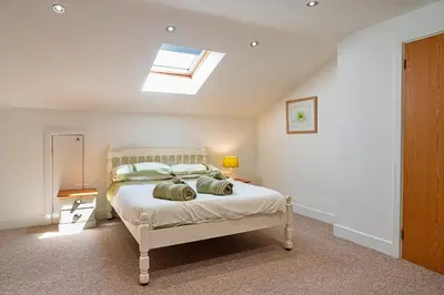 a bedroom with a bed with a skylight at Finest Retreats - Stable Barn Apartment at Bodmin Moor in Saint Breward