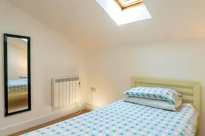 a bedroom with a bed and a mirror at Finest Retreats - Stable Barn Apartment at Bodmin Moor in Saint Breward
