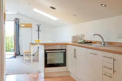 a white kitchen with a sink and a stove at Finest Retreats - Stable Barn Apartment at Bodmin Moor in Saint Breward