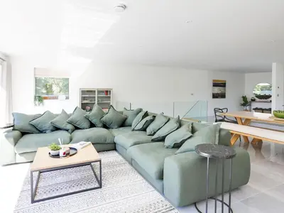 a living room with a green couch and a table at 1 Zeath in Polzeath