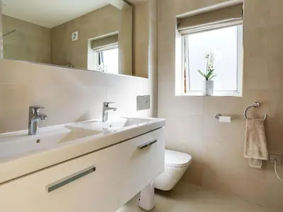 a bathroom with a sink and a toilet and a mirror at 1 Zeath in Polzeath